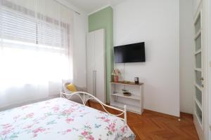 1 dormitorio con 1 cama y TV en la pared en Apartment Anka, en Opatija