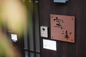 ein Schild an einer Wand mit asiatischer Schrift darauf in der Unterkunft Hotel Neiraku in Nara