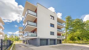 an apartment building with balconies on a street at Apartamenty Sun & Snow Szafirowa in Mielno