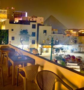 een restaurant met tafels en stoelen en uitzicht op de piramide bij Alaa Eldein Pyramids Lights in Caïro