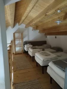 a row of mattresses in a room with wooden ceilings at Rifugio Manfre in Belpasso