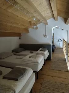 a row of beds in a room with wooden ceilings at Rifugio Manfre in Belpasso