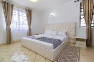 Azure Skyline Villa, 3BR Modern Condo Nakuru City. في ناكورو: غرفة نوم مع سرير أبيض كبير في غرفة