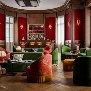 un restaurant avec des meubles verts et rouges et un bar dans l'établissement Hôtel de la Poste, à Beaune