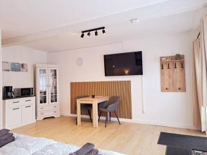 a living room with a table and a kitchen at Ruhiges 1-Zimmer-Appartement, Büsum (4km), Nordsee in Oesterdeichstrich