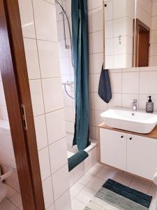 uma casa de banho branca com um lavatório e um chuveiro em Ruhiges 1-Zimmer-Appartement, Büsum (4km), Nordsee em Oesterdeichstrich
