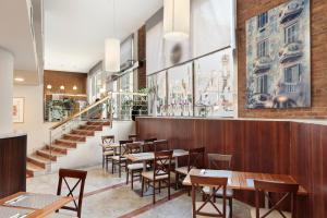 un restaurant avec des tables en bois, des chaises et des escaliers dans l'établissement Hotel Best Aranea, à Barcelone