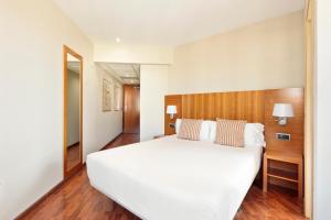 a bedroom with a large white bed and wooden floors at Hotel Best Aranea in Barcelona