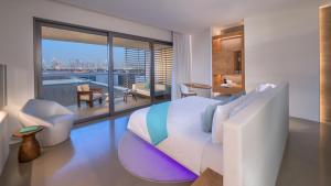 a bedroom with a bed and a view of the city at Nikki Beach Resort & Spa Dubai in Dubai