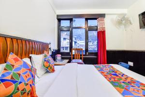 a bedroom with two beds and a window at FabHotel Park View I in Manāli