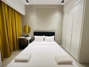 een slaapkamer met een groot wit bed en een bureau bij KL SUITES AT AXON RESIDENCE KLCC in Kuala Lumpur