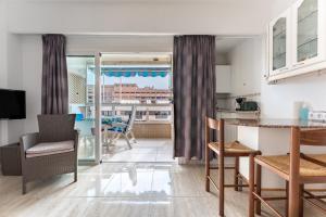 フエンヒロラにあるMarina view, sunny one bedroom pyrのテーブルと椅子のあるキッチンとリビングルーム