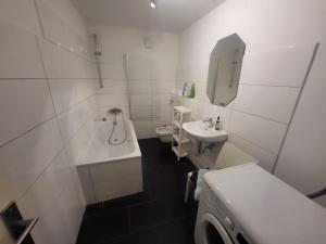 Un baño con lavabo, bañera e inodoro. en Wohnen auf Zeit Hagen Monteurunterkunft & Übergangswohnungen, en Hagen 48 fotos más