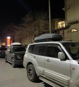 Un todoterreno blanco estacionado en un estacionamiento por la noche en OLD CITADEL with Terace, en Bukhara