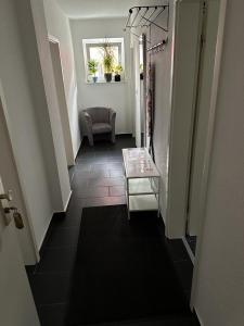 a hallway with a stairway with a table and a chair at Monteurwohnungen Wohnen auf Zeit in Hagen