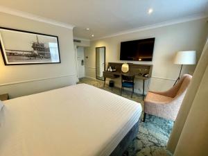 um quarto de hotel com uma cama e uma secretária em London Croydon Aerodrome Hotel, BW Signature Collection em Croydon