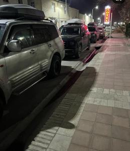 un grupo de autos estacionados en una calle por la noche en OLD CITADEL with Terace, en Bukhara