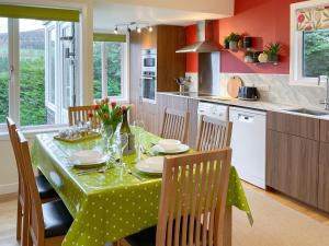 a kitchen with a table with a green table cloth at 2 Bed in Blair Atholl 87927 in Bridge of Tilt