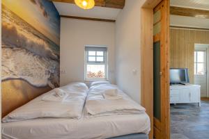 a bed in a room with a painting on the wall at Welcome in - Rustig gelegen gastenverblijf met eigen tuin, slaapkamer en badkamer in Koudekerke