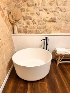 a white bath tub in a bathroom with a stone wall at Sister residence rooms in Bari