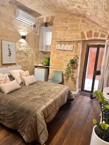 - une chambre avec un grand lit dans un mur en pierre dans l'établissement Sister residence rooms, à Bari