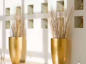 two gold vases with grass in them on a wall at Sofitel Algiers Hamma Garden in Alger