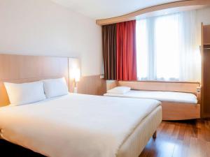 アリカンテにあるIbis Hotel Alicanteのベッド2台と窓が備わるホテルルームです。