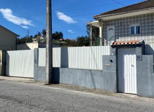 a white fence next to a house with a gate at Alojamento D Duarte in Gouveia
