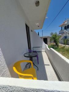 a yellow chair and table on the side of a building at Garden Studios N3 in Archangelos
