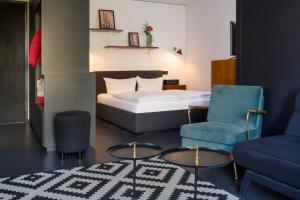 1 dormitorio con 1 cama, 2 sillas y sofá en Brera Serviced Apartments Munich Schwabing en Múnich