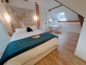een slaapkamer met een groot bed met een teddybeer erop bij La Villa Martinière in Bièvres