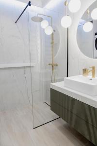 a bathroom with a glass shower and a sink at APARTAMENT WRAŻEŃ Kraków in Kraków