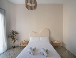 ein Schlafzimmer mit einem weißen Bett mit weißer Bettwäsche und Kissen in der Unterkunft Apartment Mosaic Giralda in Sevilla