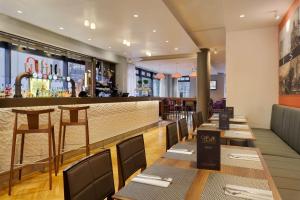 a restaurant with wooden tables and a bar at DoubleTree by Hilton London Angel Kings Cross in London