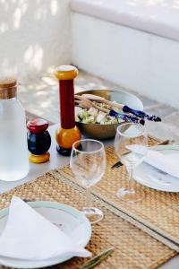 una mesa con copas de vino y un tazón de comida en Villa Adara, splendide villa avec piscine et vue mer, en Aegina Town