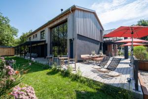 a house with a patio with chairs and an umbrella at FriesThinkLand in Tönning