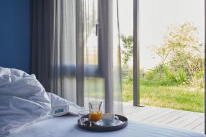 a bed with a tray with two glasses of orange juice at FriesThinkLand in Tönning