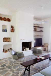 Una sala de estar con mesa y sillas y una chimenea. en Villa Adara, splendide villa avec piscine et vue mer, en Aegina Town 57 fotos más