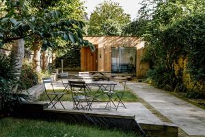 a patio with a table and chairs in a yard at Mason & Fifth, Primrose Hill in London