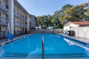 a swimming pool at a apartment complex with blue water at La Quinta Inn by Wyndham Pensacola in Pensacola