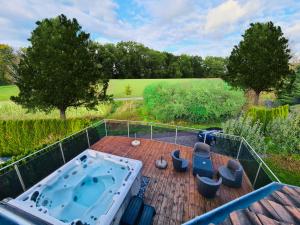 una terraza con vistas panorámicas a una bañera de hidromasaje. en Villa with Pool - Leon's Holiday Homes, en Dottikon