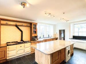 a large kitchen with a large island in the middle at Colzium Farmhouse in Blitterlees