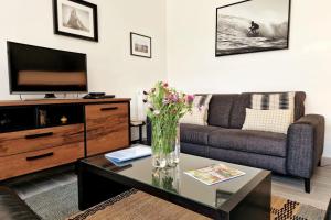 ein Wohnzimmer mit einem Sofa und einem TV in der Unterkunft Villa 8 pers proche hypercentre parking gratuit in Vannes