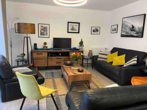 ein Wohnzimmer mit einem Sofa und einem Tisch in der Unterkunft Villa 8 pers proche hypercentre parking gratuit in Vannes
