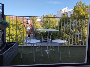 2 chaises et une table sur un balcon dans l'établissement Amalien 12, à Munich