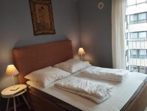 Un dormitorio con una cama con almohadas blancas y una ventana en Amalien 12, en Múnich