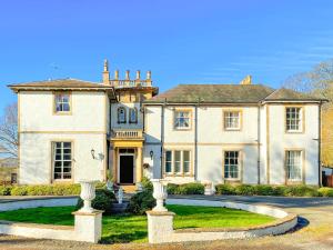 uma casa grande com uma entrada em frente em The Mansion House At Kirkhill em Arniston