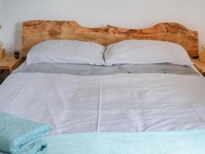 a white bed with two pillows and a wooden headboard at Wee Shot - Uk46613 in Tain