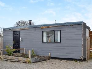 a gray tiny house with a black door at Wee Shot - Uk46613 in Tain