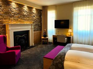 a hotel room with a bed and a fireplace at Augustiner Hotel in Hillesheim